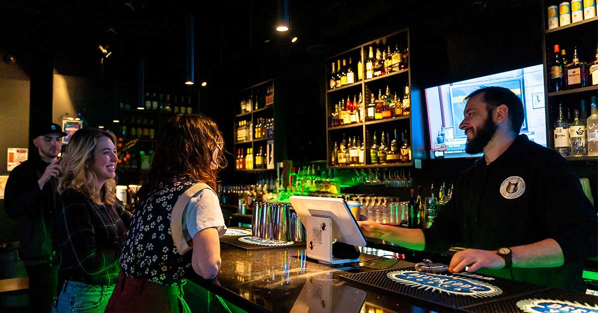 People gathered at the bar of Night Kitty in Lexington, Ky.