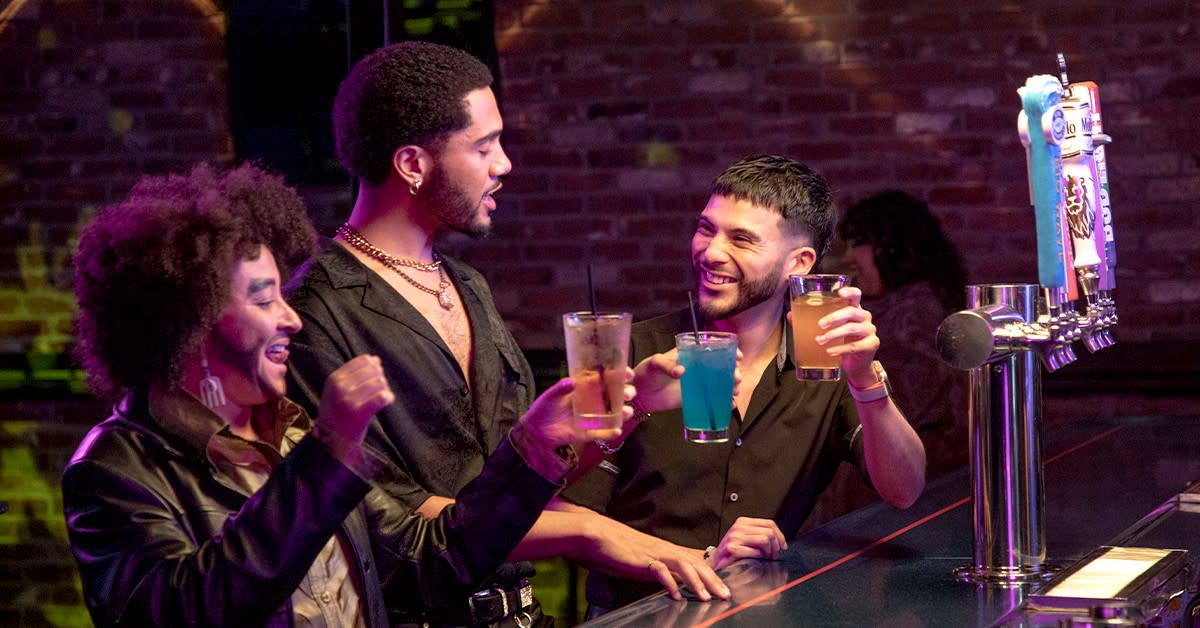 Three friends enjoying cocktails at a bartop