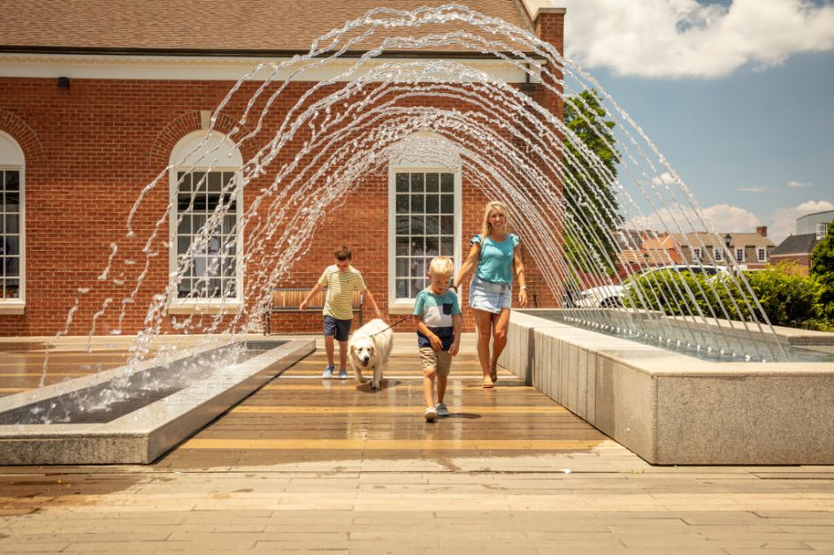 Family walking under fountain in Downtown Kannapolis