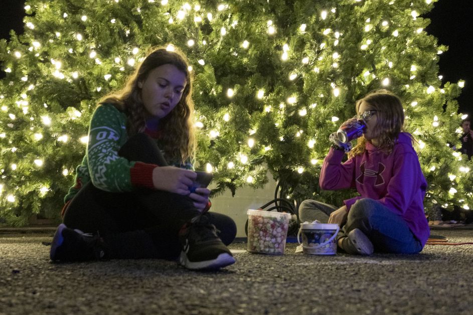 Mom and son sitting in front of town Christmas Tree