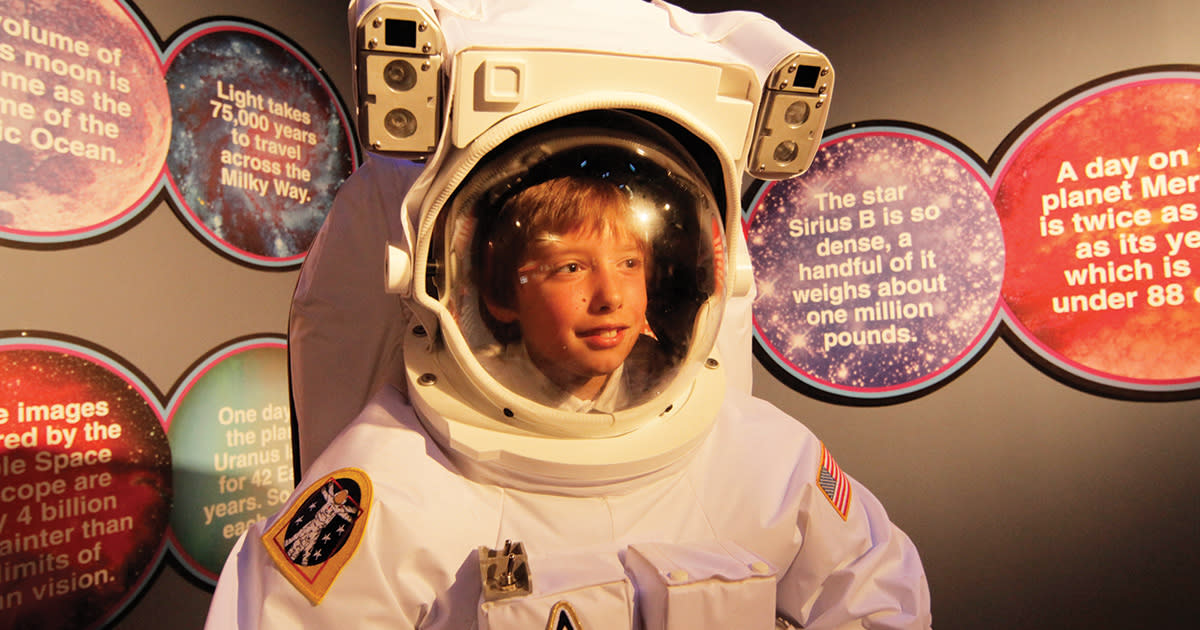 A boy poses inside an astronaut's spacesuit at WonderWorks in Myrtle Beach, SC