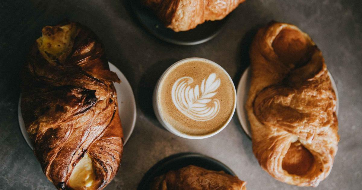 Range of sweet filled pastries from My Bakery surrounding a latte