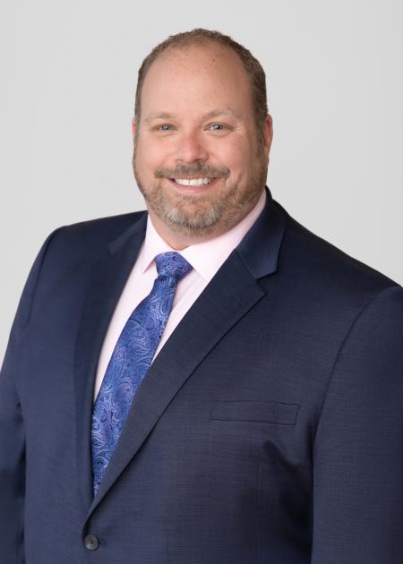 man in a blue suit with a pink shirt and blue tie