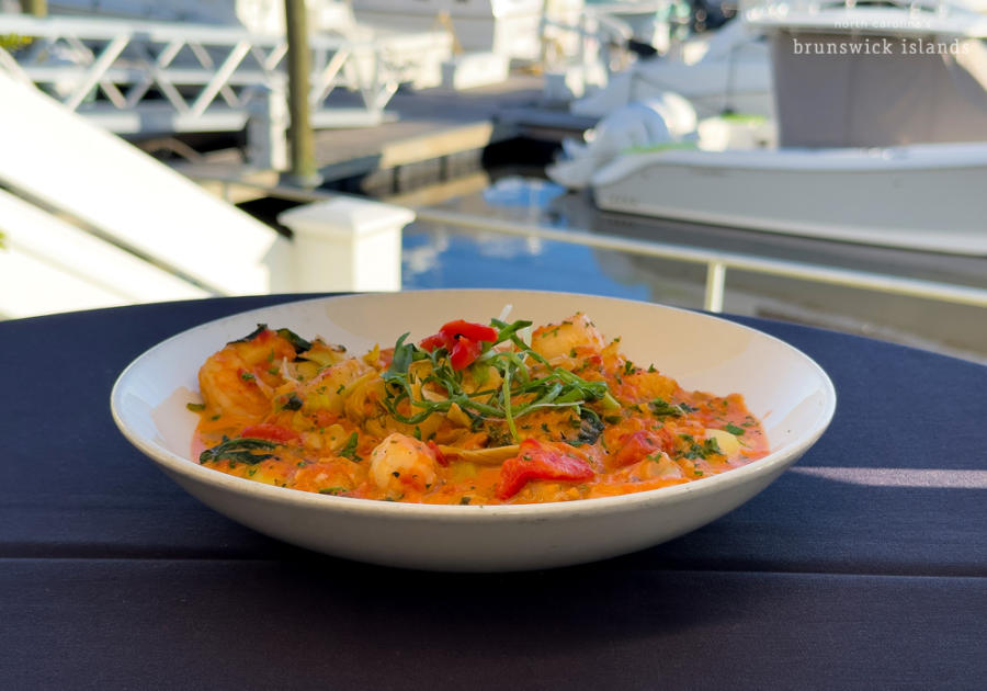 a bowl of food on an outdoor table at a waterfront restaurant