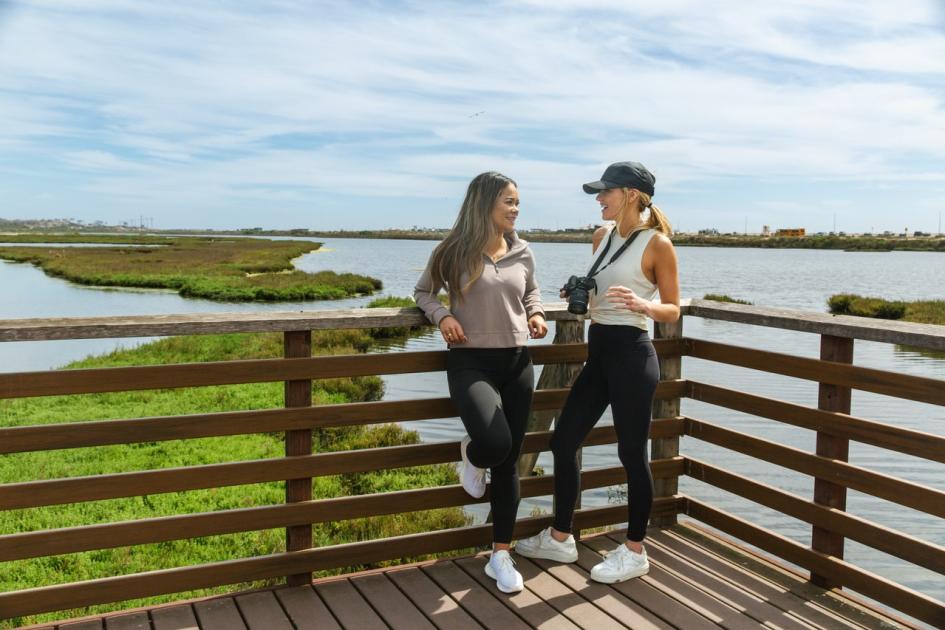 Two friends pose for a picture at the overlook, enjoying things to do at Bolsa Chica State Ecological Reserve.