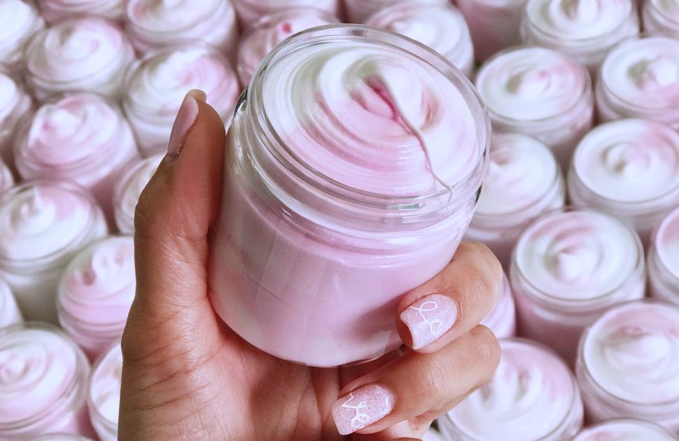 Woman holds body cream from Bungalow 26