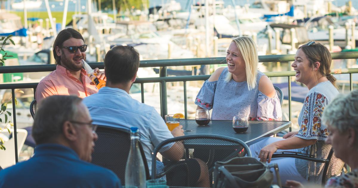 Friends laugh and catch up while dining on the Patio at West End Tavern in Traverse City MI