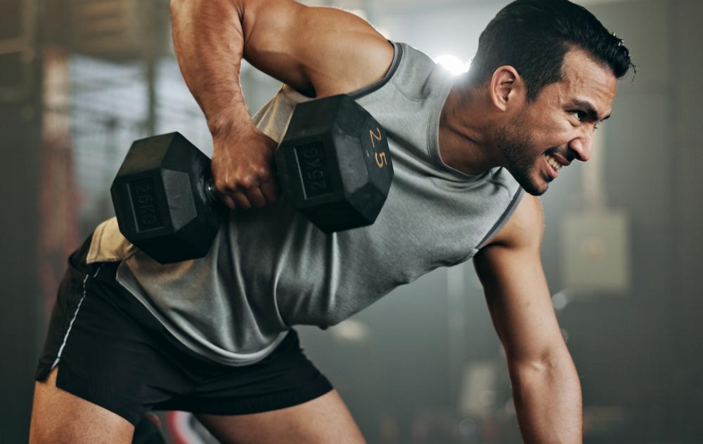 Man doing bycept curl at a gym.