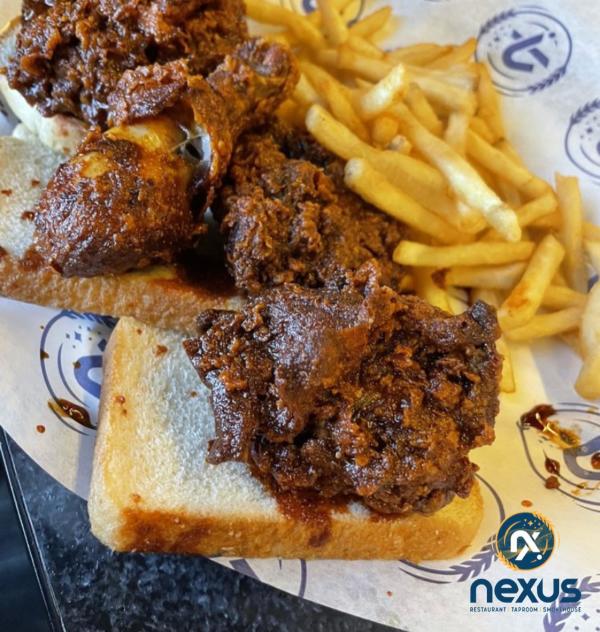 Nexus Brewery's NM Hot Chicken on white bread with a side of french fries.