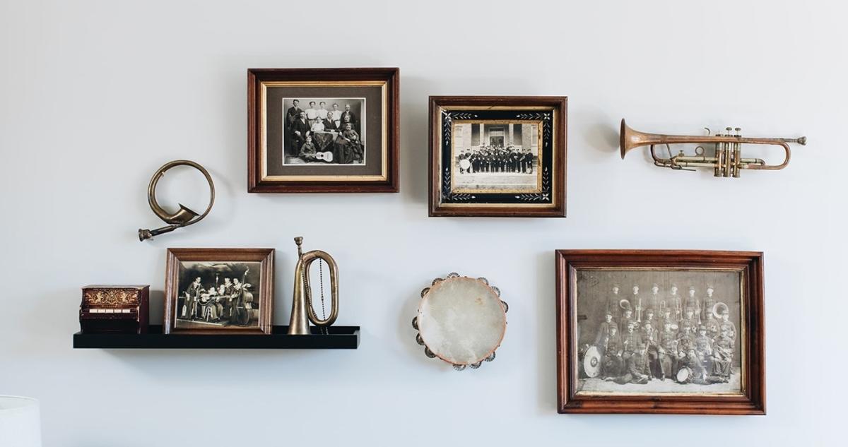 A collection of framed artwork and instruments hanging on a wall.