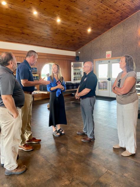 NYS Assemblymen meet with owners inside the modernized, rustic winery of Three Brothers Winery and Estates.