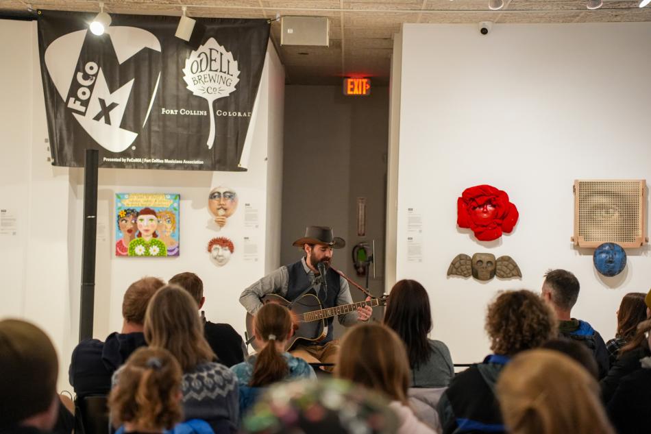 A guitar player playing at the Museum of Art.