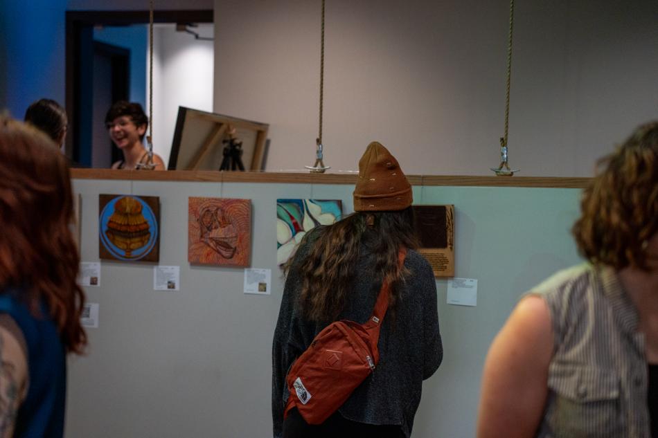 People looking at art at Fort Collins Mural Project's 10x10 Event in 2025.