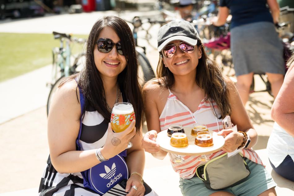 Two ladies pose for photo with New Belgium Beers in hand.