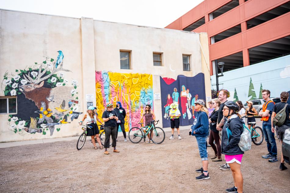 People on a bike tour of murals.
