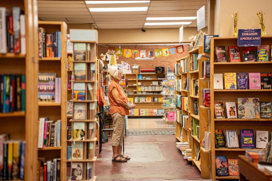 Lady looking at books in an aisle.