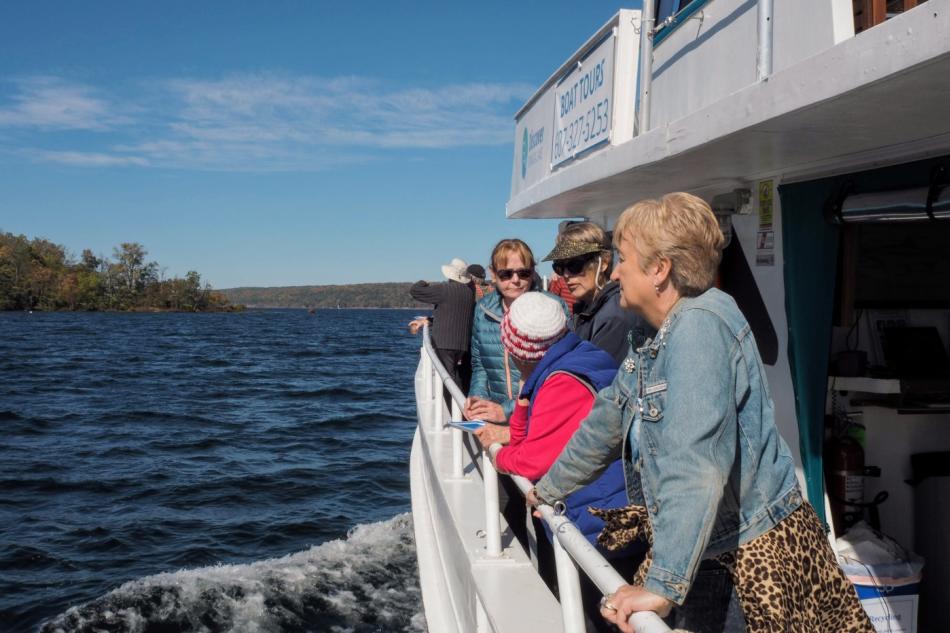 group of older people looking off a boat into the water