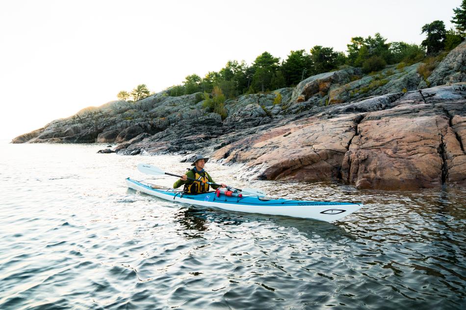 A man kayaking near unique rock formations on Lake Superior