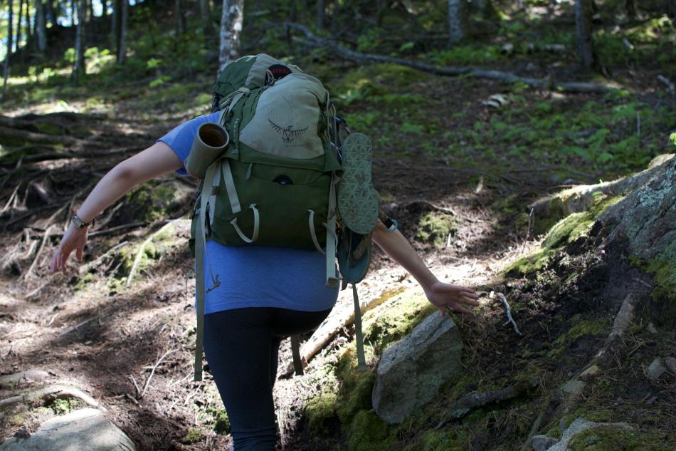 Woman traversing rocky incline on the NCT in Marquette County, MI