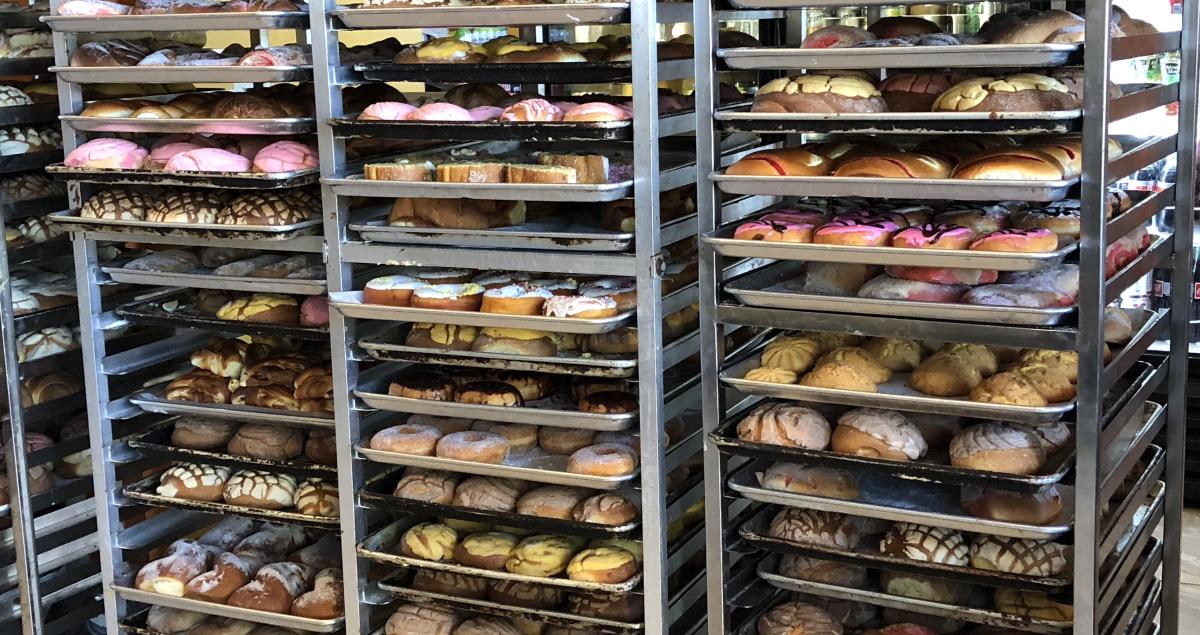 Dozens of trays full of Mexican pastries are stacked on top of each other at Las Tres Conchitas bakery in Coachella