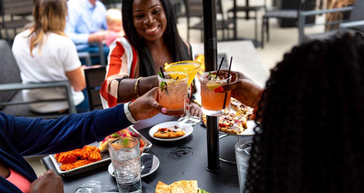 Friends eating outdoors at the Clyde Club Room