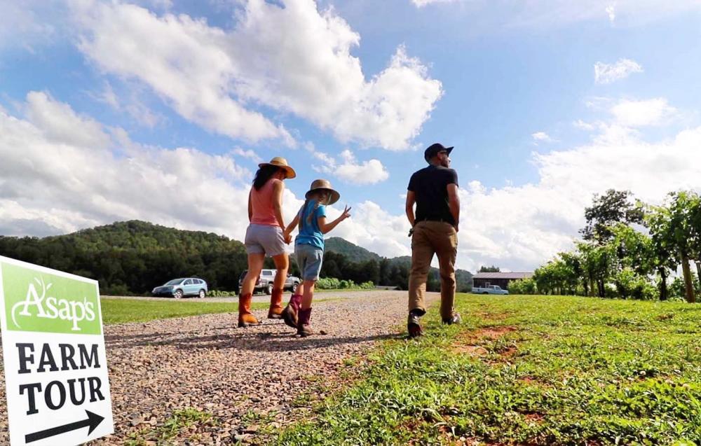 Mother, father and child walking towards farm on ASAP Farm Tour