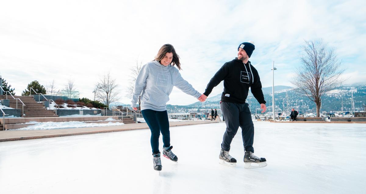 A couple skates while holding hands at the Stuart Park Skating Rink in Kelowna BC