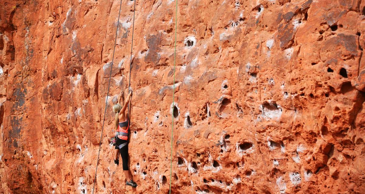 Female rock climber on a cliff wall in Southern Utah