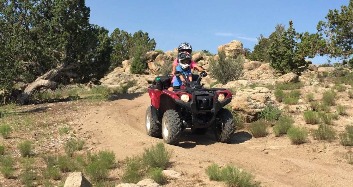An adult and child riding on a four wheeler in Utah