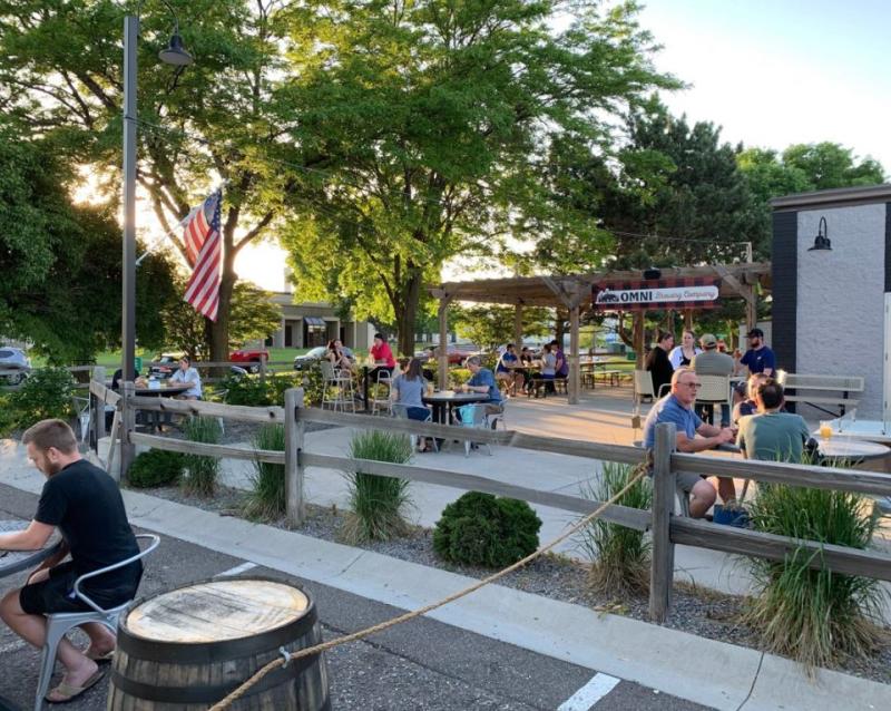 Diners eat at tables spread out across the patio and parking lot at OMNI Brewing Co.