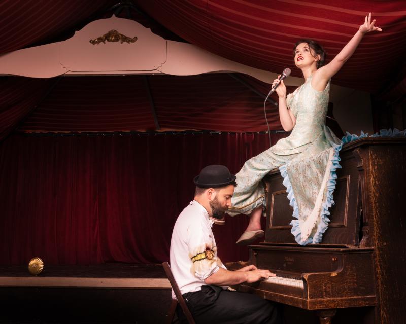 a piano player and a singer sitting on the piano