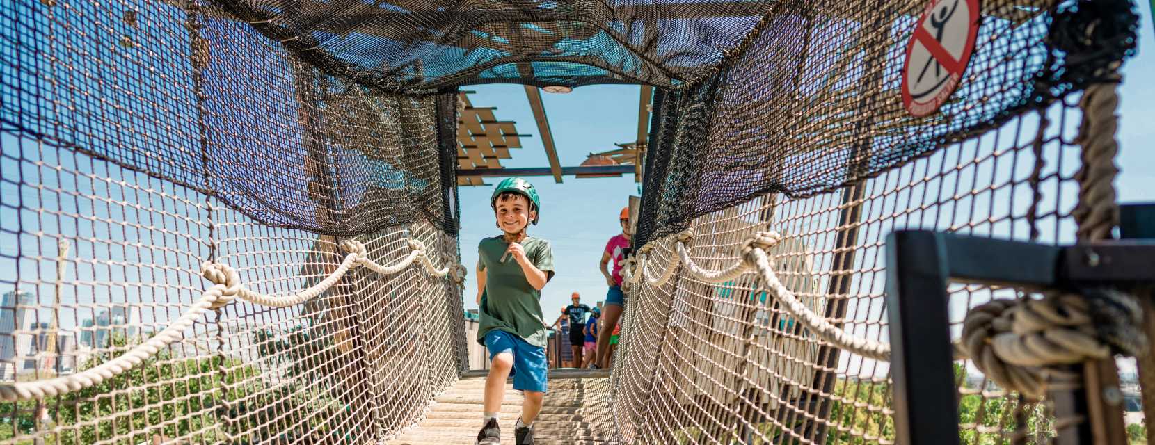 A child running down a wooden bridge at the Children's Museum of Denver at Marsico Campus.