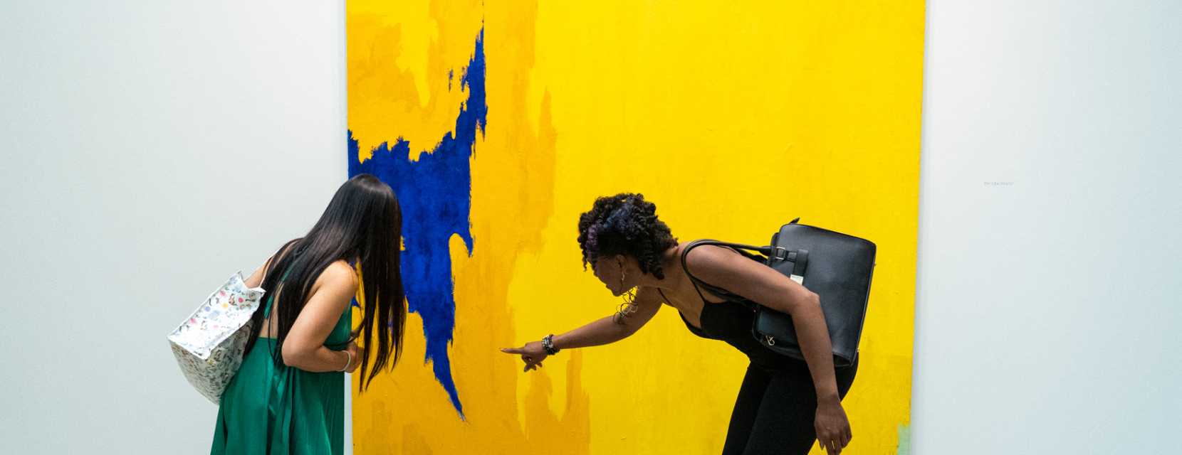 Two people look closely at a large-format painting at the Clyfford Still Museum in Denver, Colorado.
