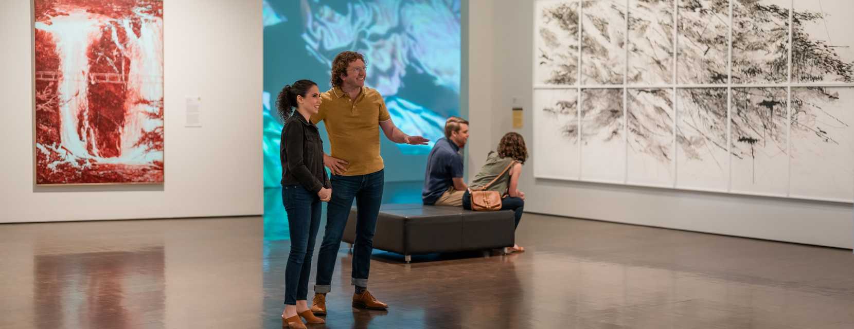 Two groups of two people enjoy the galleries inside Denver Art Museum.