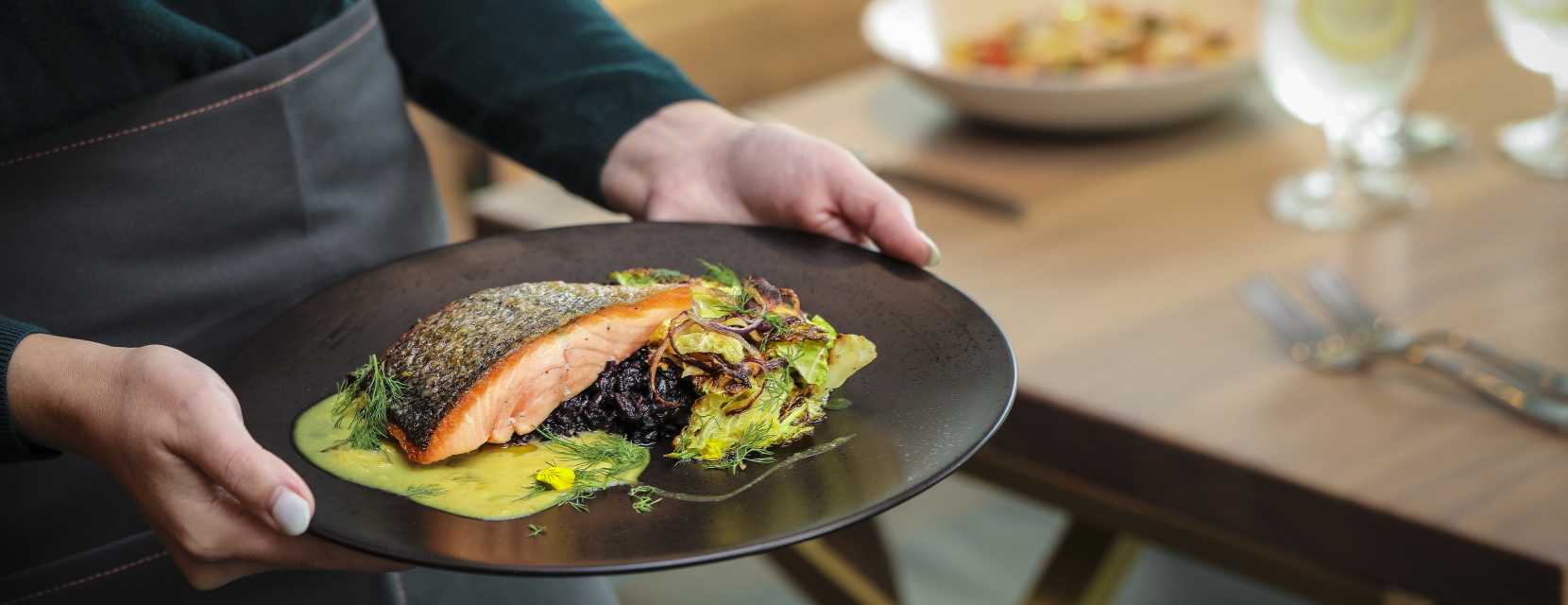 A server carries a plate of food at Denver Art Museum's restaurant, The Ponti.