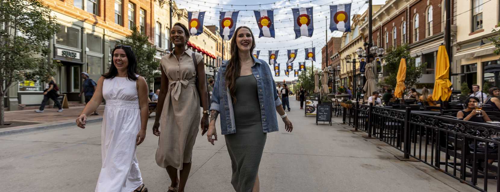 Three people walking down Larimer Square, Denver's historic block.