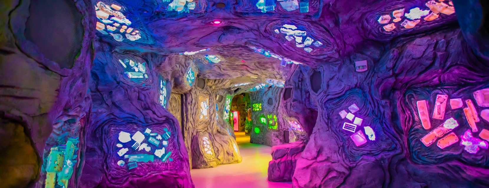 An elaborate cave lit up inside Meow Wolf Denver's Convergence Station.