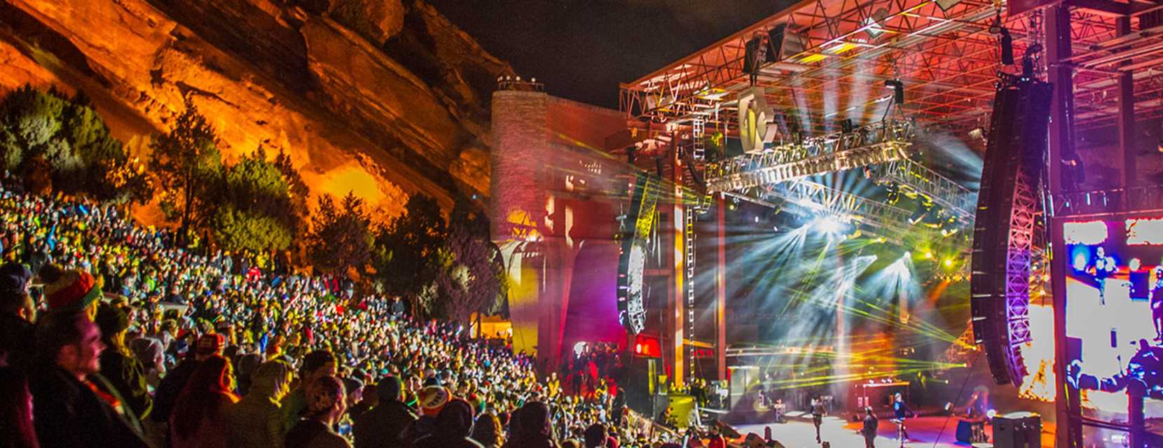 The crowd enjoys a concert at Red Rocks Amphitheatre at night