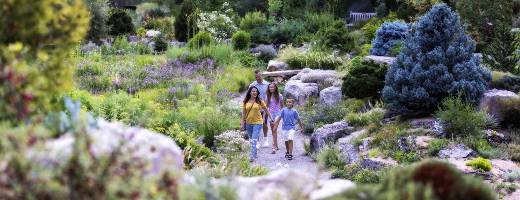 A family walks along a flower-lined path at Denver Botanic Gardens