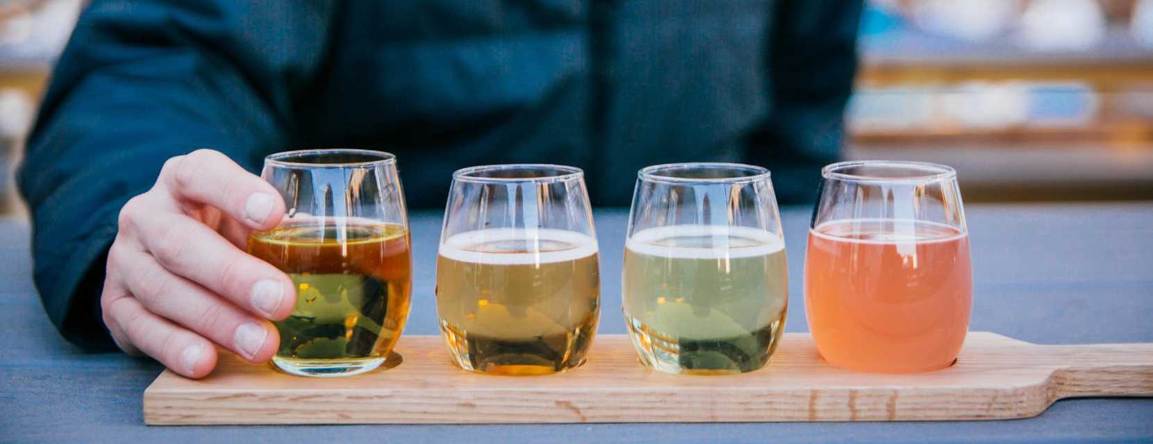 A flights of ciders is on a tray at a microbrew tour