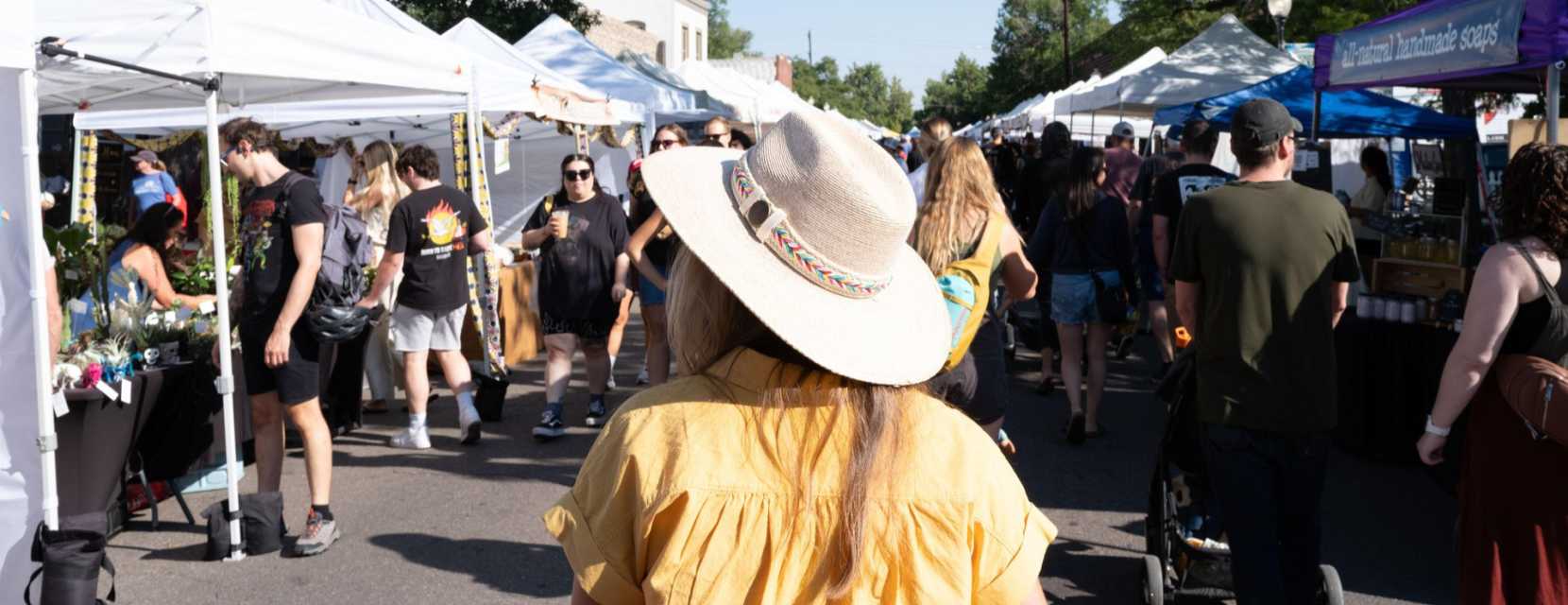 A person is walking through South Pearl Street Farmers' Market