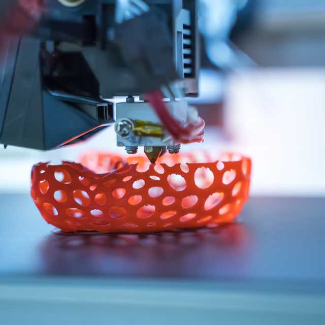 3D printer produces an orange object