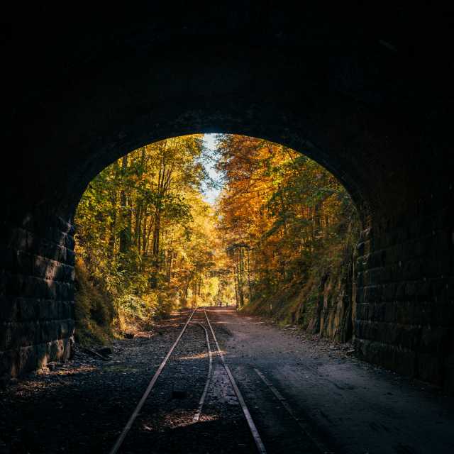 Looking out of the Howard Tunnel at the bright autumn foliage along the rail trail