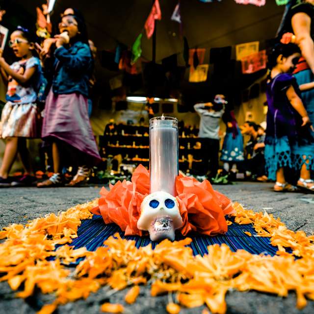 Dia De Los Muertos shrine and festival goers in Oakland CA