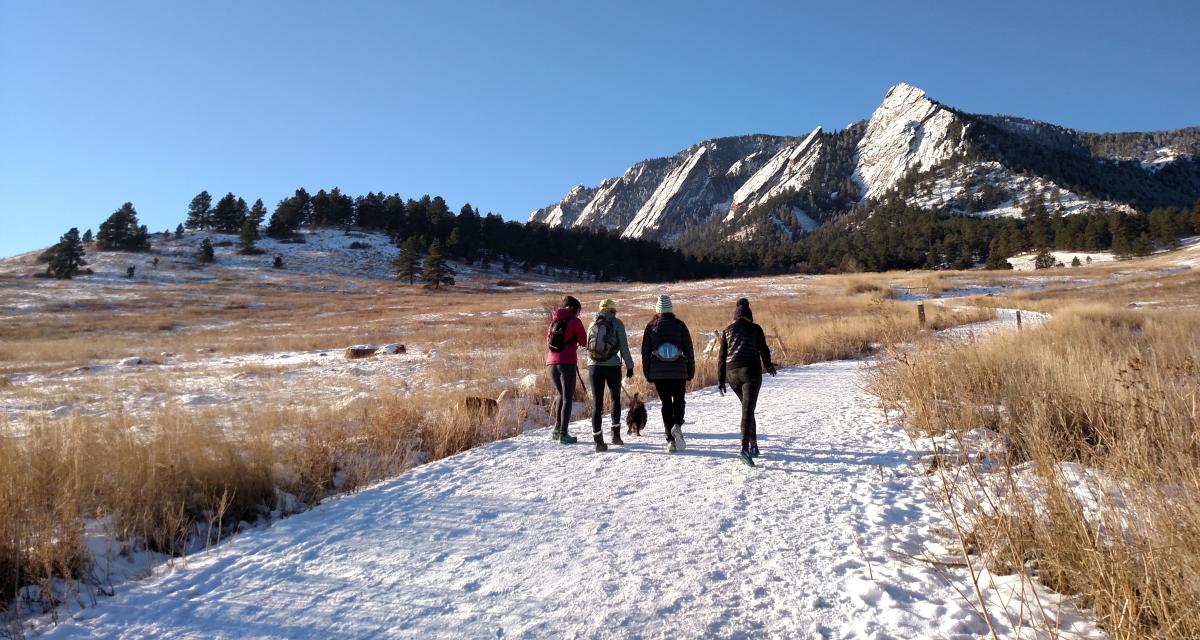 Group of four women with a dog hiking Chautauqua with the Flatirons in the winter