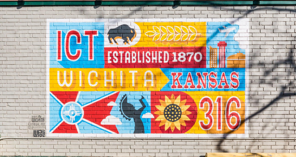 A colorful mural painted on a building features a buffalo, sunflower, Keeper of the Plains, 316, Kansas, Wichita flag and downtown Wichita skyline