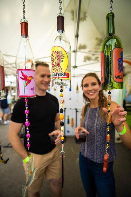 A Couple looking at bottle wind chimes at Wam Fest.