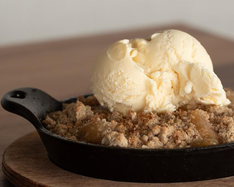 Cast iron skillet with apple crisp and ice cream