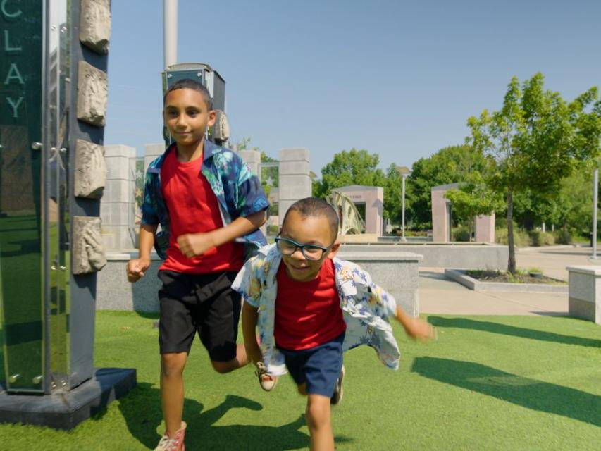 Two young boys running through Fayetteville's Veterans' Park