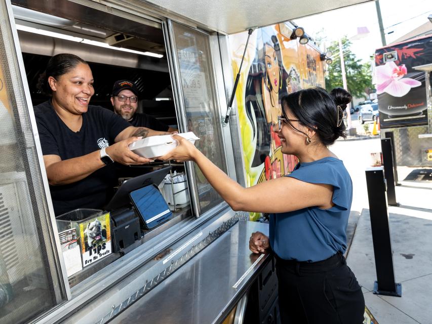 A young woman receives her food from a Fayetteville, NC food truck